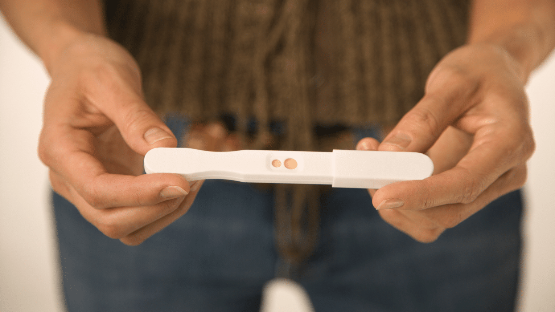 hands holding out a pregnancy test