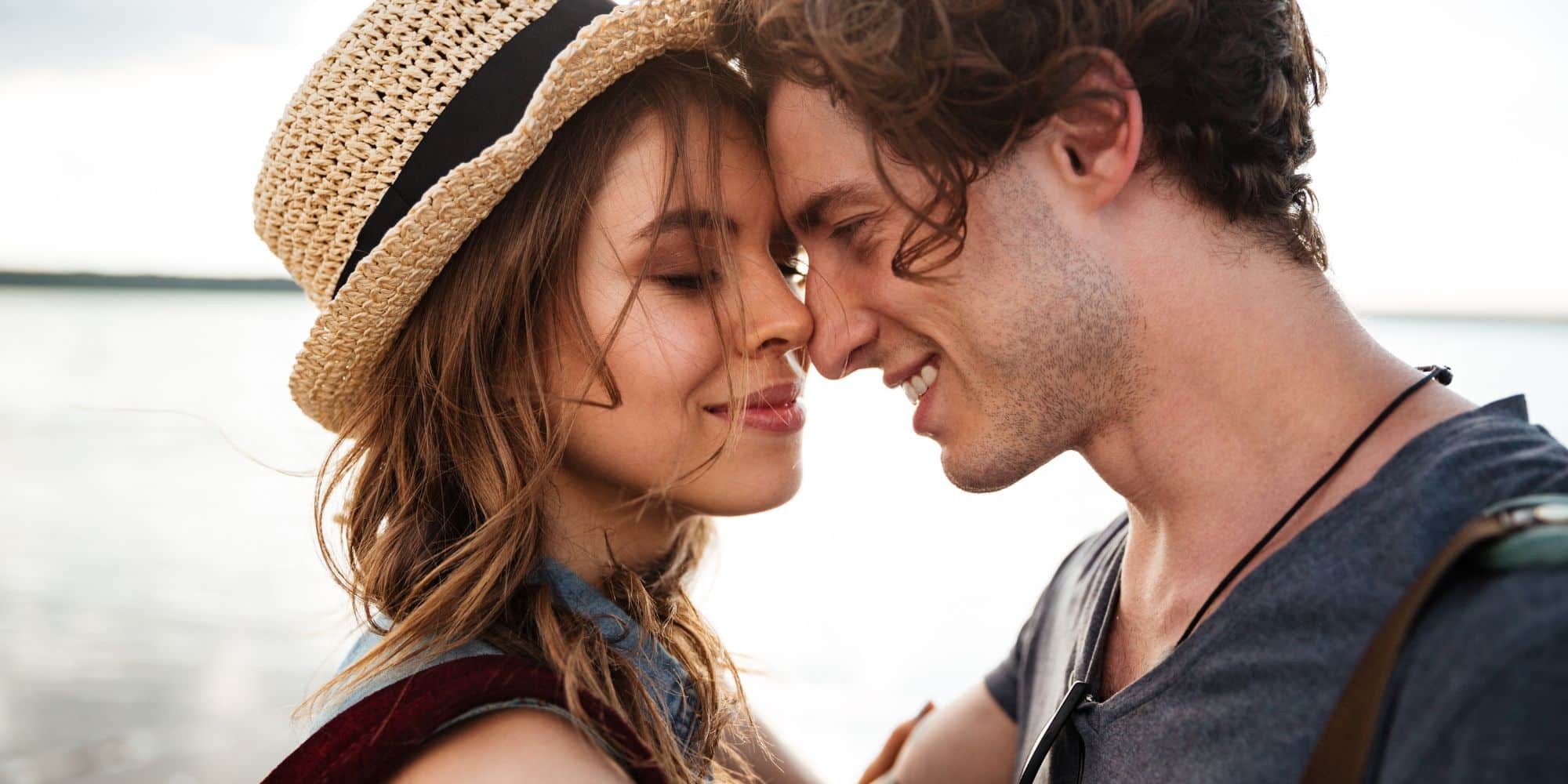 couple smiling at each other outdoors by the water