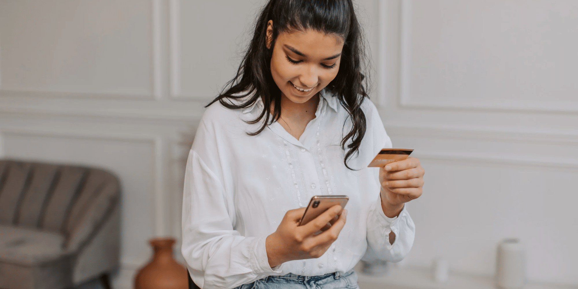 woman looking at phone looking for abortion pill cost